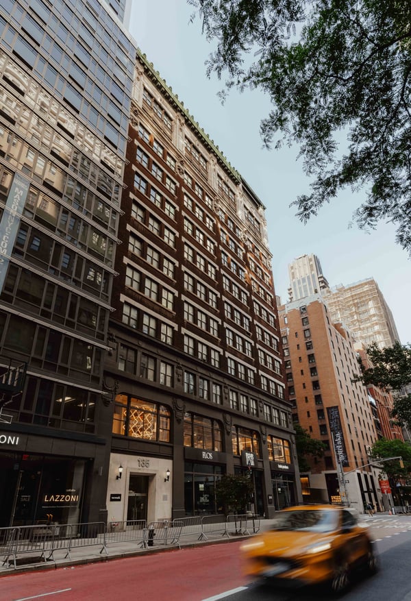 The historic Blender Workspace venue building on Madison Avenue with a yellow taxi passing by in Manhattan, New York City